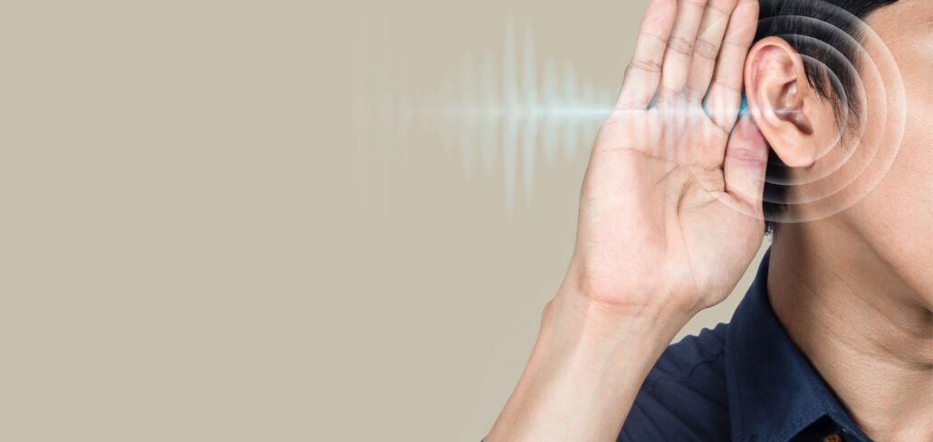 Person cupping an ear to hear better, representing audiology services and hearing loss care in Plainsboro, NJ.