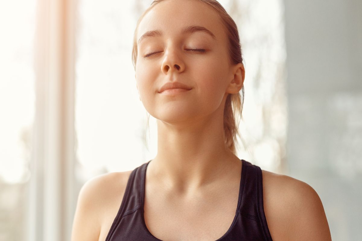 Woman calmly breathing with eyes closed, symbolizing sinus health and nasal odor treatment.