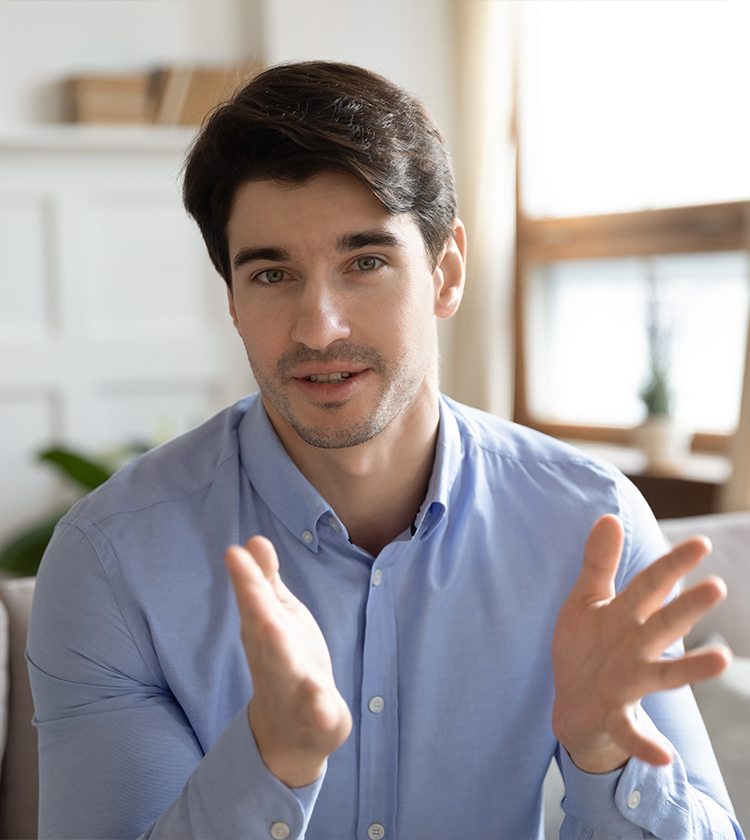 Man in a blue shirt demonstrating a voice exercise during a therapy session focused on vocal improvement techniques.