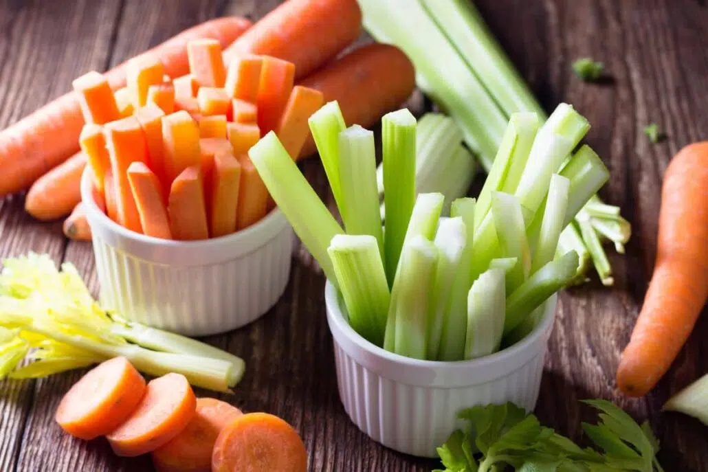 Fresh carrot and celery sticks in bowls—common foods that may cause allergic reactions in mugwort-sensitive individuals.