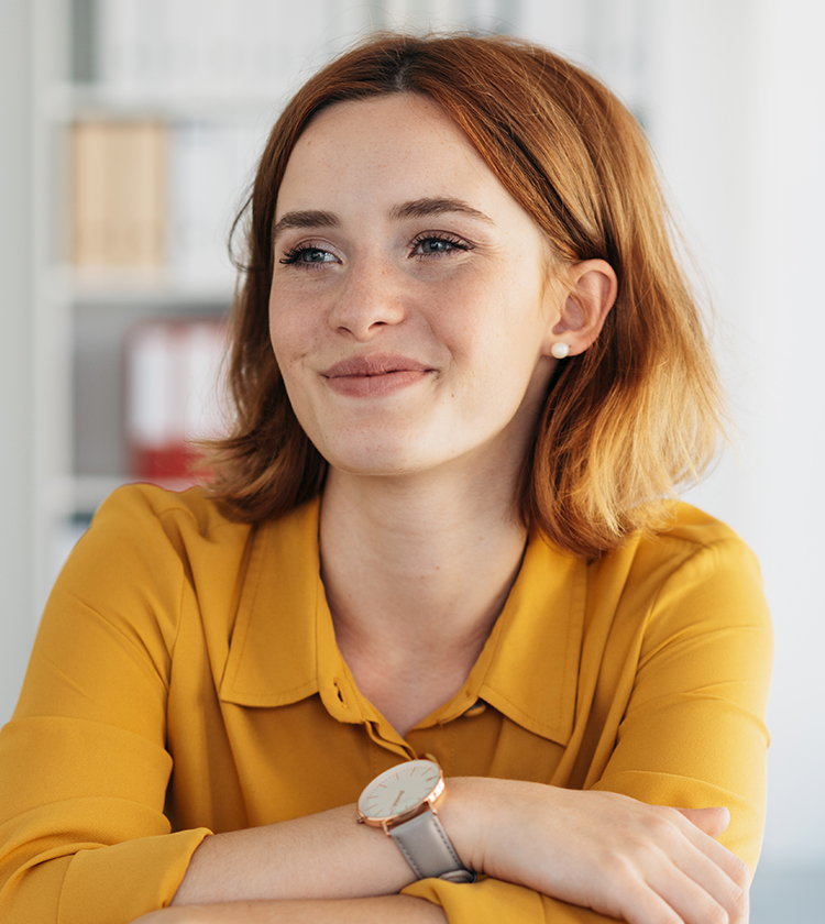 Smiling young woman with arms crossed, representing awareness of neck and branchial cleft cyst symptoms in children.
