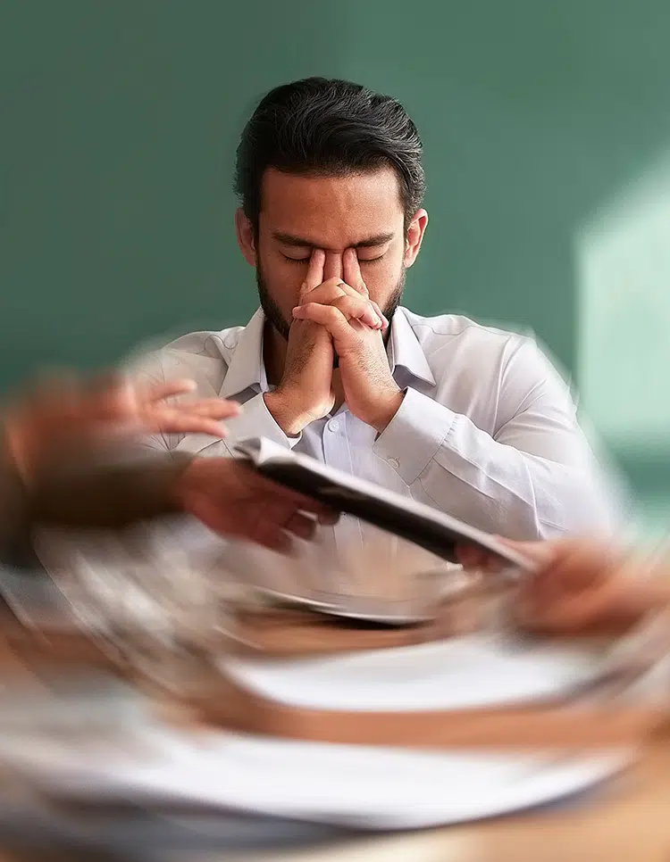 Man holding his face with spinning visual effect, representing stress as a risk factor for dizziness and vertigo.