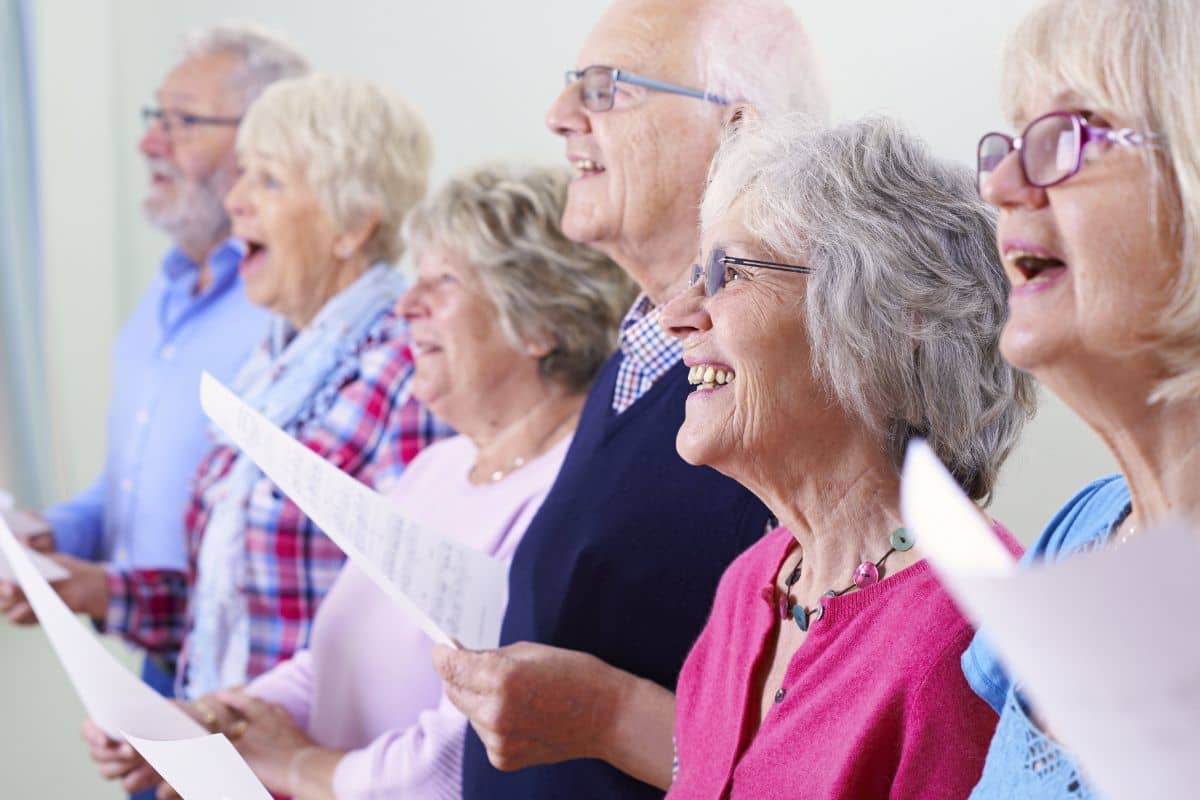 Elderly choir members singing in harmony during rehearsal.