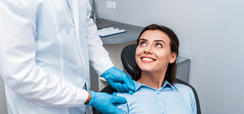 Smiling patient speaking with doctor wearing gloves, emphasizing importance of timely ear infection treatment to avoid risks