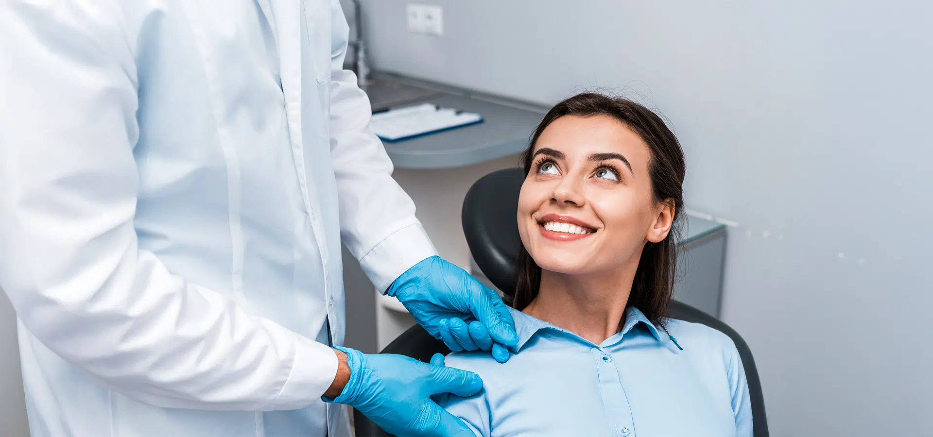 Smiling patient speaking with doctor wearing gloves, emphasizing importance of timely ear infection treatment to avoid risks