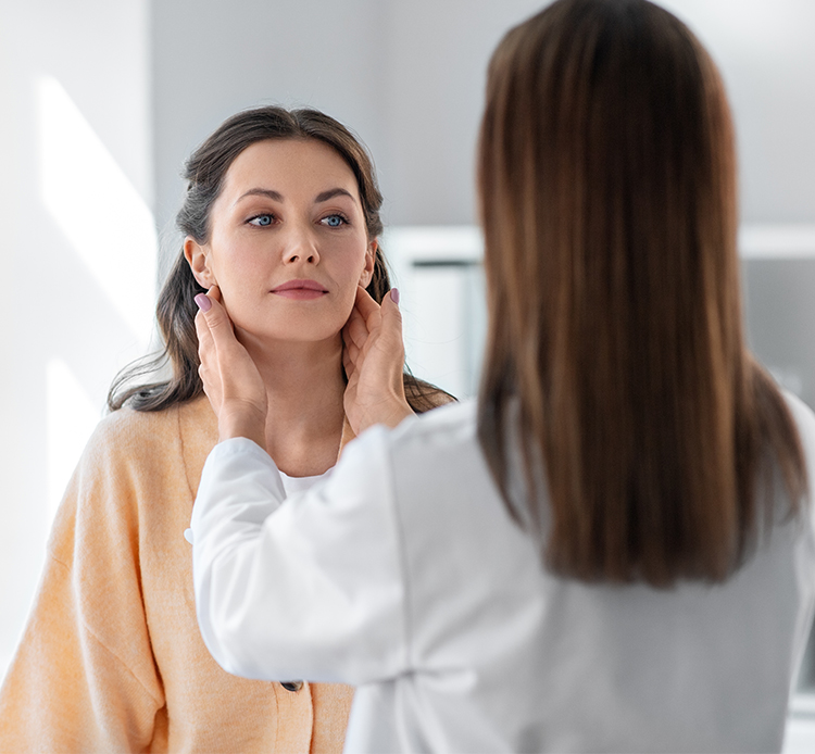 Female ENT specialist examining a woman’s throat during a consultation for sinus, voice, or hearing concerns