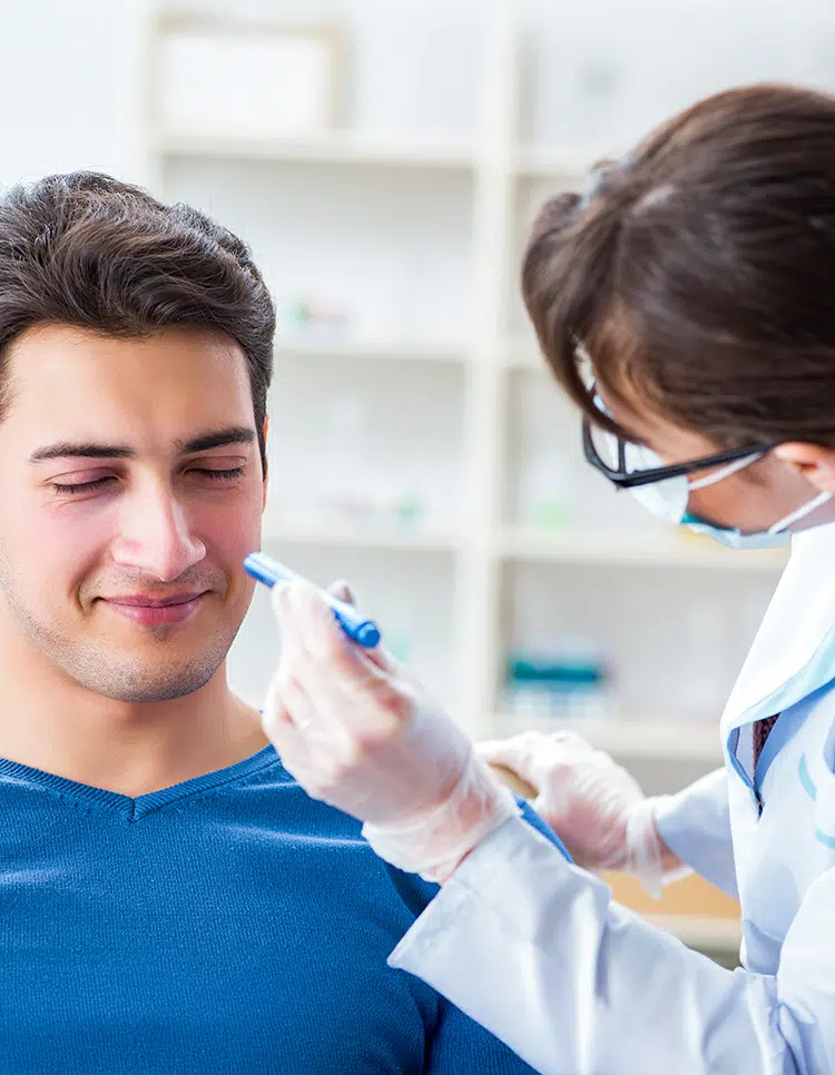 Doctor discussing personalized sinus infection treatment options with male patient during clinical consultation