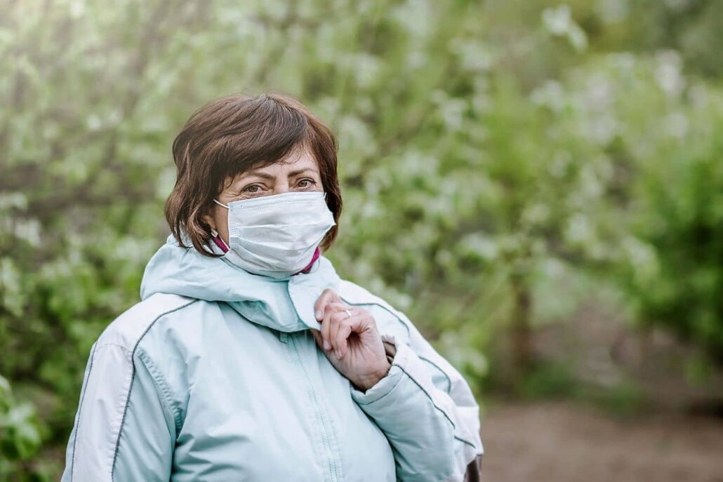 Woman wearing protective face mask outdoors, illustrating sinus protection during poor air quality exposure