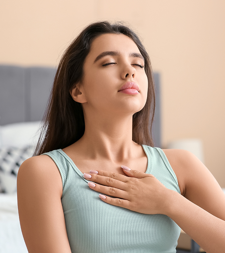 Woman practicing deep breathing exercise indoors, supporting airway health and improving sleep quality in insomnia patients