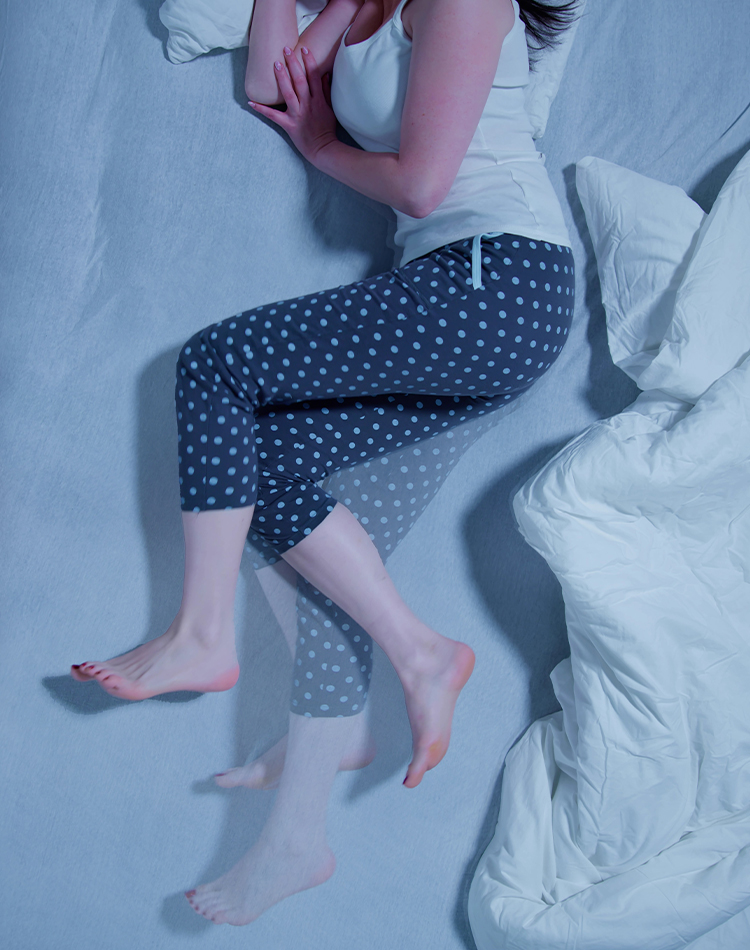 Person lying in bed with repeated leg movements, illustrating sleep-related movement disorder disrupting rest