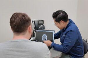 ENT specialist reviews sinus CT scan with patient in Philadelphia clinic for urgent ear, nose, and throat care.