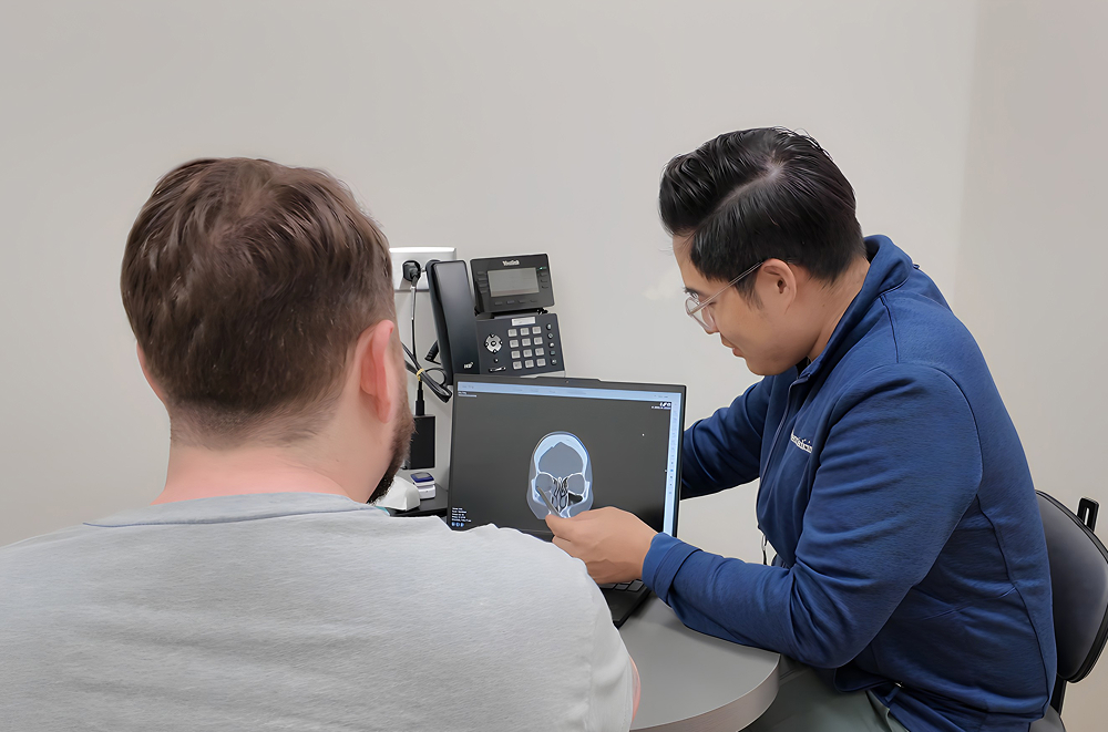 ENT specialist reviews sinus CT scan with patient in Philadelphia clinic for urgent ear, nose, and throat care.