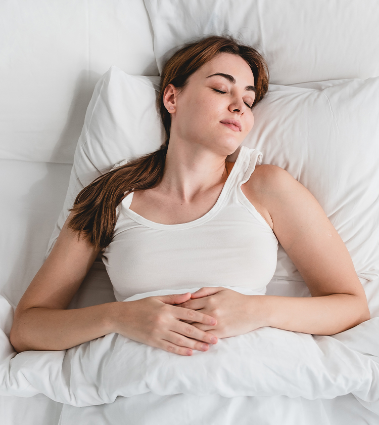 Woman resting calmly on bed, illustrating stable breathing, low arousal index, and improved sleep quality