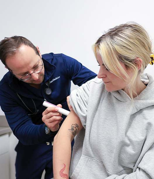 Doctor performing allergy skin test on patient arm to diagnose skin and eye allergic reactions in clinic