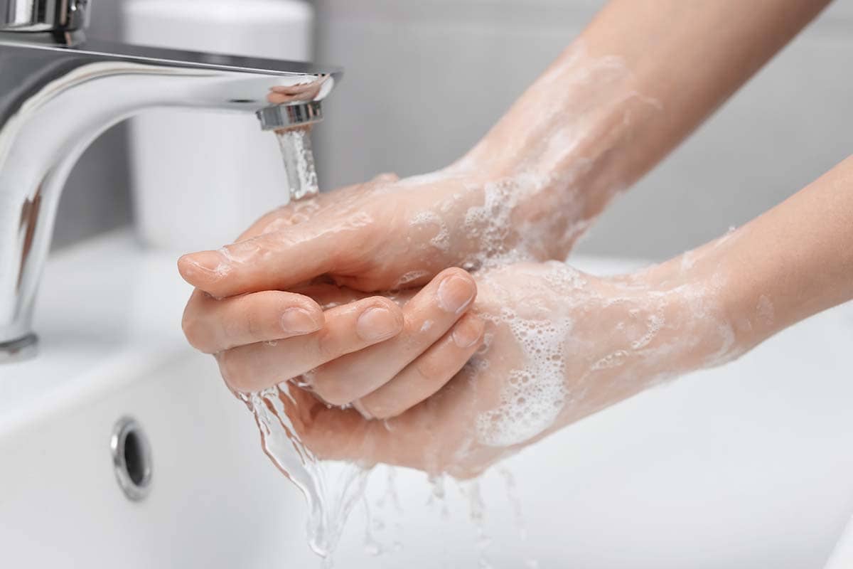 Close-up of hands being washed at a sink to illustrate prevention tips for sinus pressure and sinus infections.