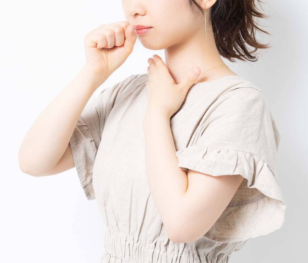 Person holding their throat in discomfort, representing the pain and strain caused by an untreated voice disorder