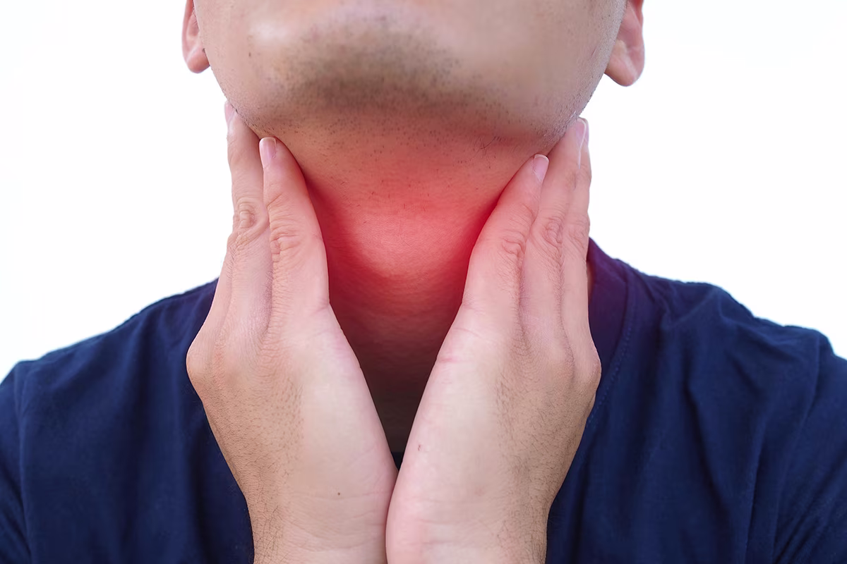 Person holding a painful neck, illustrating common causes of neck masses, swelling, and throat discomfort.