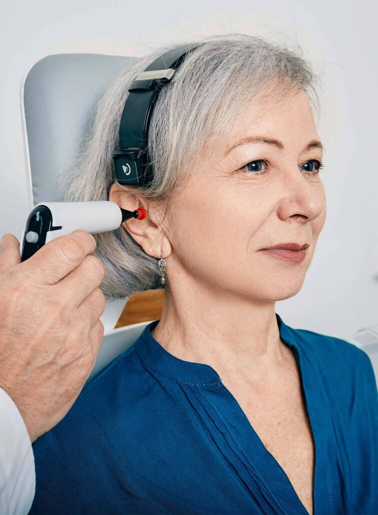 Healthcare provider examining a patient’s ear during an urgent care visit for ENT and airway symptoms.
