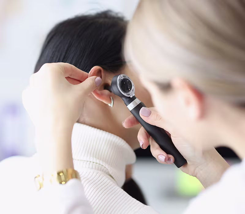 ENT specialist examining a patient’s ear to diagnose outer, middle, and inner ear infections.