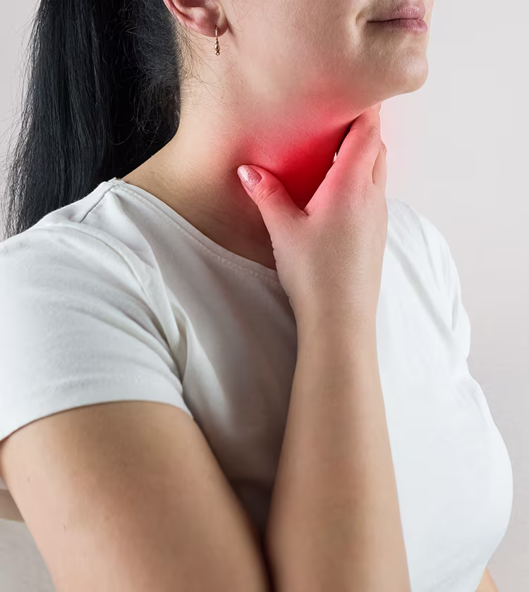 Woman experiencing throat discomfort illustrating potential mild side effects after a FEES procedure.