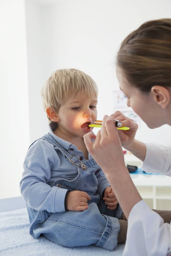 ENT specialist examining a child for snoring and sleep-related breathing issues during a pediatric evaluation.