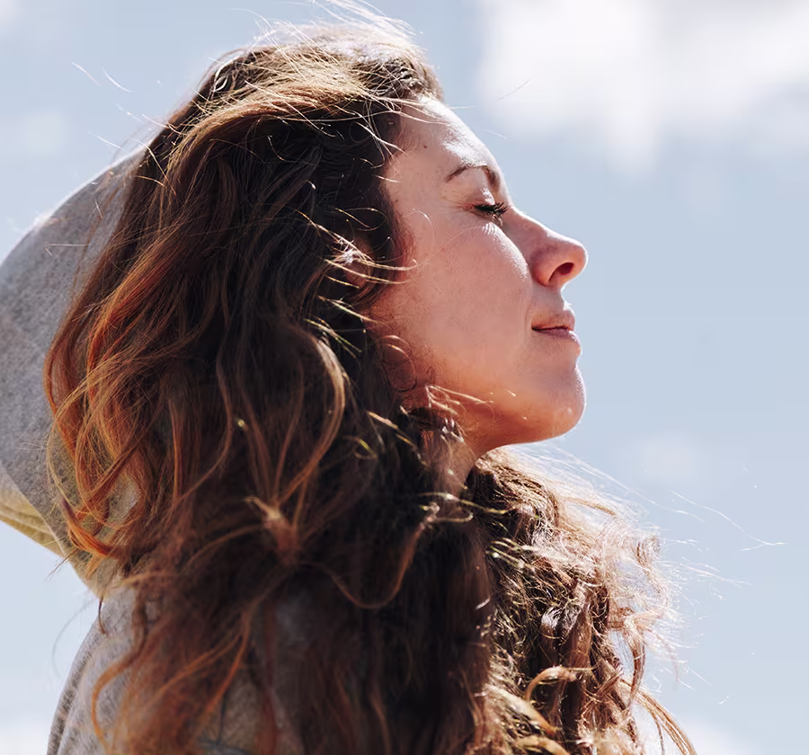 Woman breathing comfortably outdoors before turbinate reduction procedure and nasal airway treatment.