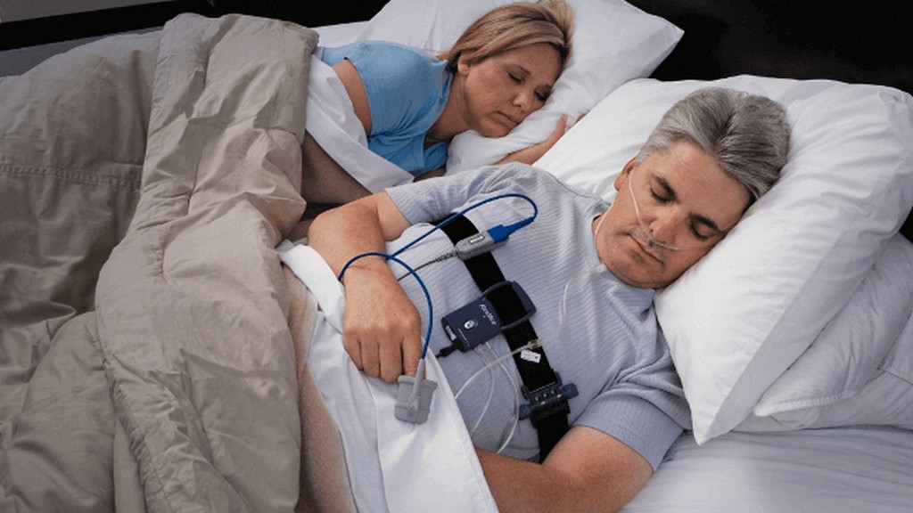 Patient undergoing a sleep study with monitoring equipment to diagnose sleep apnea and assess sleep quality.