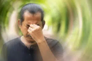 Man experiencing vertigo symptoms and dizziness while seeking guidance for urgent ENT care and balance concerns.